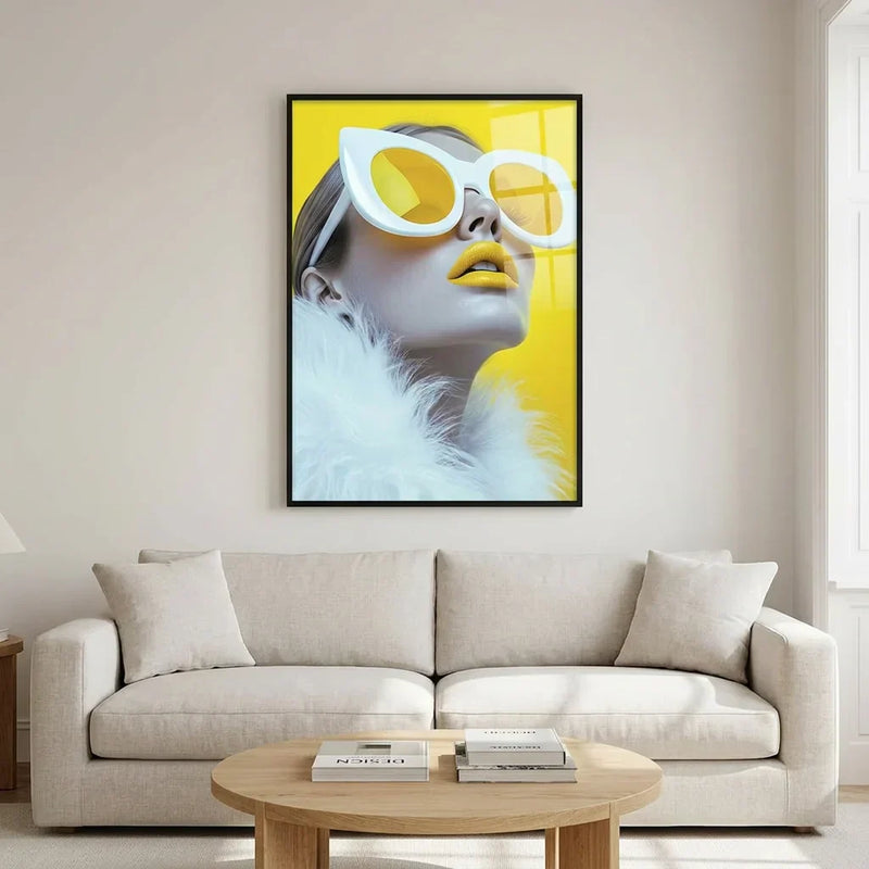 Bold yellow pop art portrait in white sunglasses framed above a pale linen sofa in a calm, neutral living room